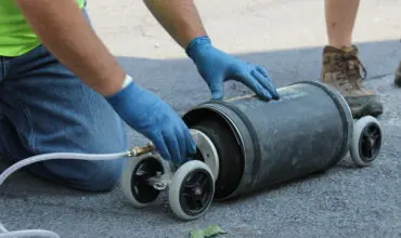 A person with gloved hands holding an equipment